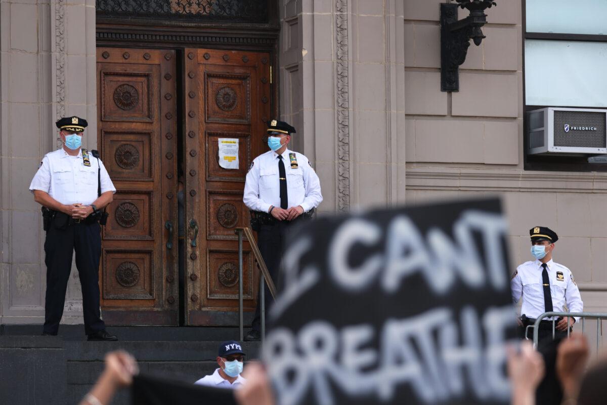 Police officers stand guard as protesters gather in front of the 120th NYPD precinct on the sixth anniversary of Eric Garner's death in Tompkinsville, Staten Island, in New York City on July 17, 2020. (Michael M. Santiago/Getty Images)