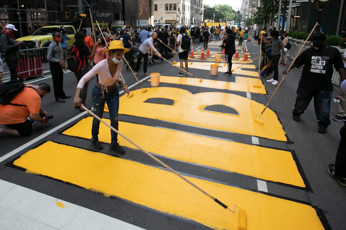 Azia Toussaint, left, participates in the painting of Black Lives Matter on Fifth Avenue in front of Trump Tower in New York City on July 9, 2020. (Mark Lennihan/AP Photo)