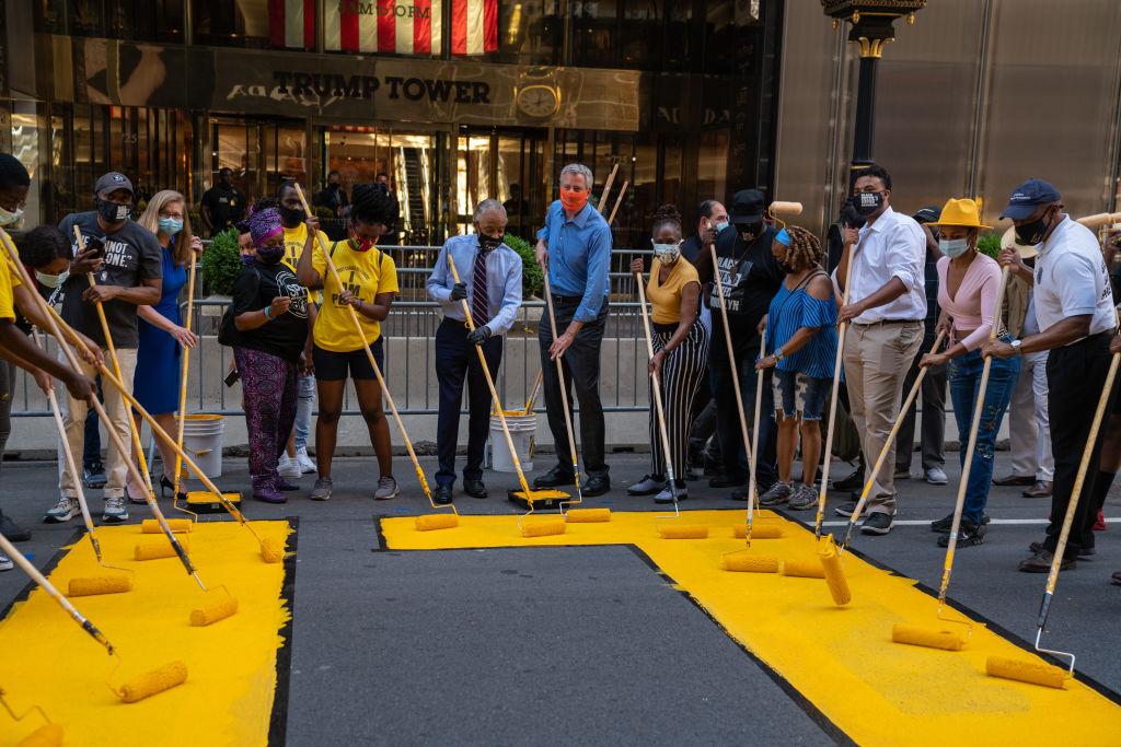 New York City Mayor Bill de Blasio, his wife, Chirlane McCray, and Rev. Al Sharpton help paint a Black Lives Matter mural on Fifth Avenue directly in front of Trump Tower on July 9, 2020, in New York City. (David Dee Delgado/Getty Images)