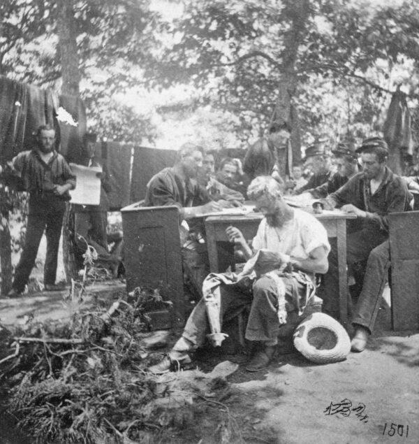 Northern soldiers from the Army of the Potomac take a respite from battle to write letters and mend clothing during the American Civil War, early 1860s. (Hulton Archive/Getty Images)