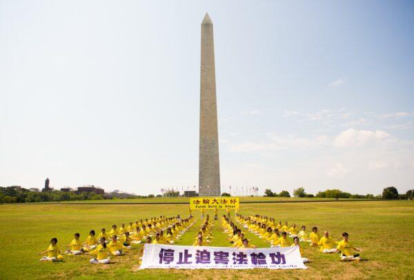Over one hundred of Falun Gong practitioners are meditating on the grass in front of the Washington Monument to urge the stopping of the CCP's persecution of their spiritual practice, in Washington, D.C., on July 19, 2020. (Lisa Fan/The Epoch Times)