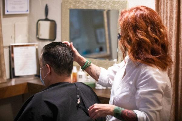 Owner Christine Maniaci cuts a friend's hair at Salon Touche in Redondo Beach, Calif., on July 16, 2020. (John Fredricks/The Epoch Times)