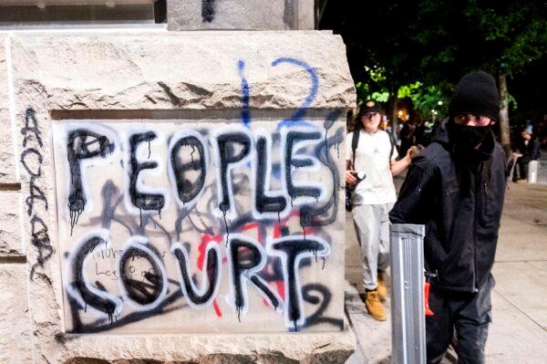 Grafitti is shown during a demonstration outside the Mark O. Hatfield United States Courthouse in Portland, Ore., July 20, 2020. (Noah Berger/AP Photo)