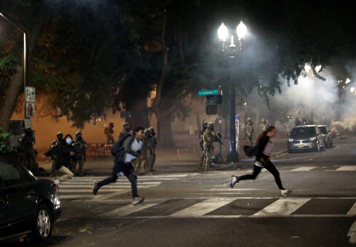 Federal law enforcement officials fire tear gas during a riot in Portland, Ore., on July 19, 2020. (Caitlin Ochs/Reuters)
