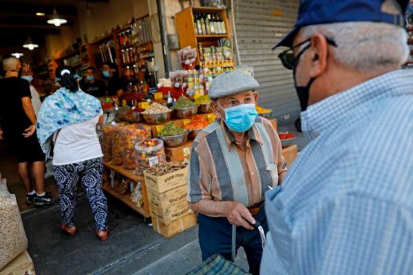 Men stand clad in masks (due to the COVID-19 coronavirus pandemic) at the Mahane Yehuda Market in Jerusalem on July 16, 2020. (Menahem Kahana / AFP via Getty Images)