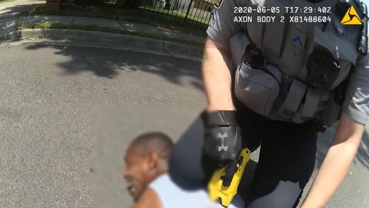 In this still image from bodycam video, Fairfax police officer Tyler Timberlake kneels on La Monta Gladney on June 5, 2020. (Fairfax County Police Department)