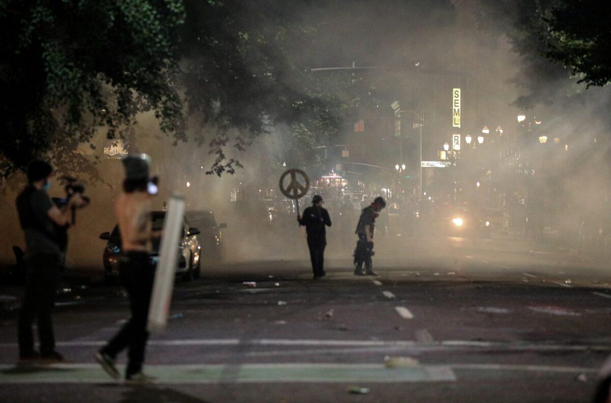 Demonstrators gather amid lingering tear gas fired by federal law enforcement officials in Portland, Ore., on July 19, 2020. (Caitlin Ochs/Reuters)