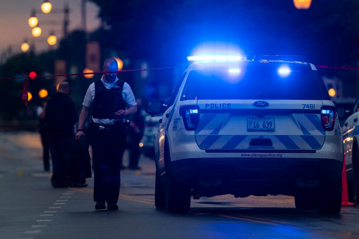 Chicago police investigate the scene of a mass shooting where more then a dozen people were shot in the Gresham neighborhood, on July 21, 2020. (Tyler LaRiviere/Sun-Times/AP)