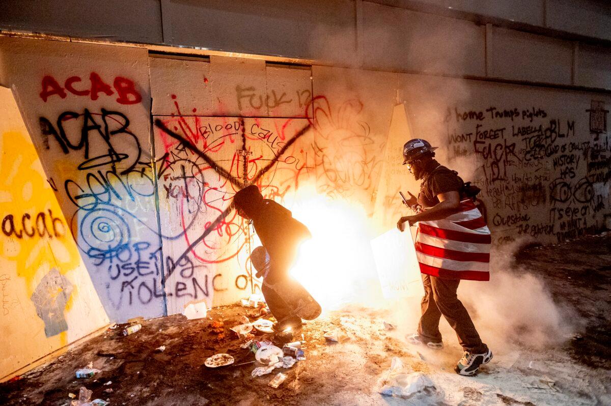 Rioters next to a fire they set at the Mark O. Hatfield United States Courthouse in Portland, Ore., on July 22, 2020. (Noah Berger/AP Photo)