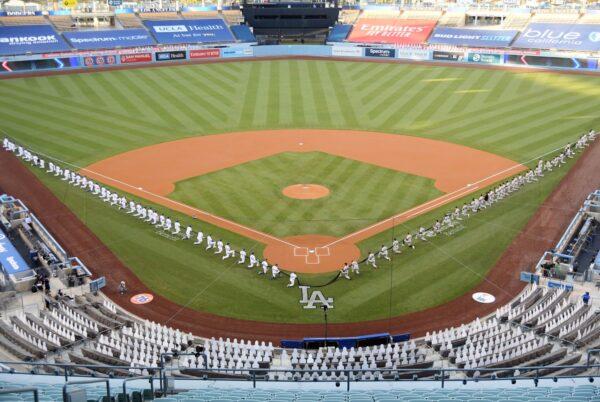The Los Angeles Dodgers and the San Francisco Giants gather on the field before their game at Dodger Stadium in Los Angeles on July 23, 2020. (Harry How/Getty Images)