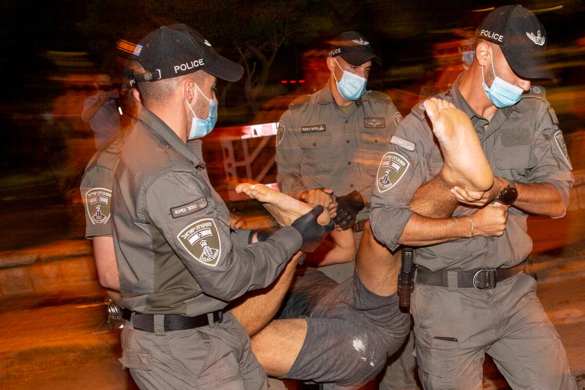 Israeli police officers arrest a demonstrator during a protest against Israel's Prime Minister Benjamin Netanyahu outside his residence in Jerusalem, on July 24, 2020. (Ariel Schalit/AP Photo)