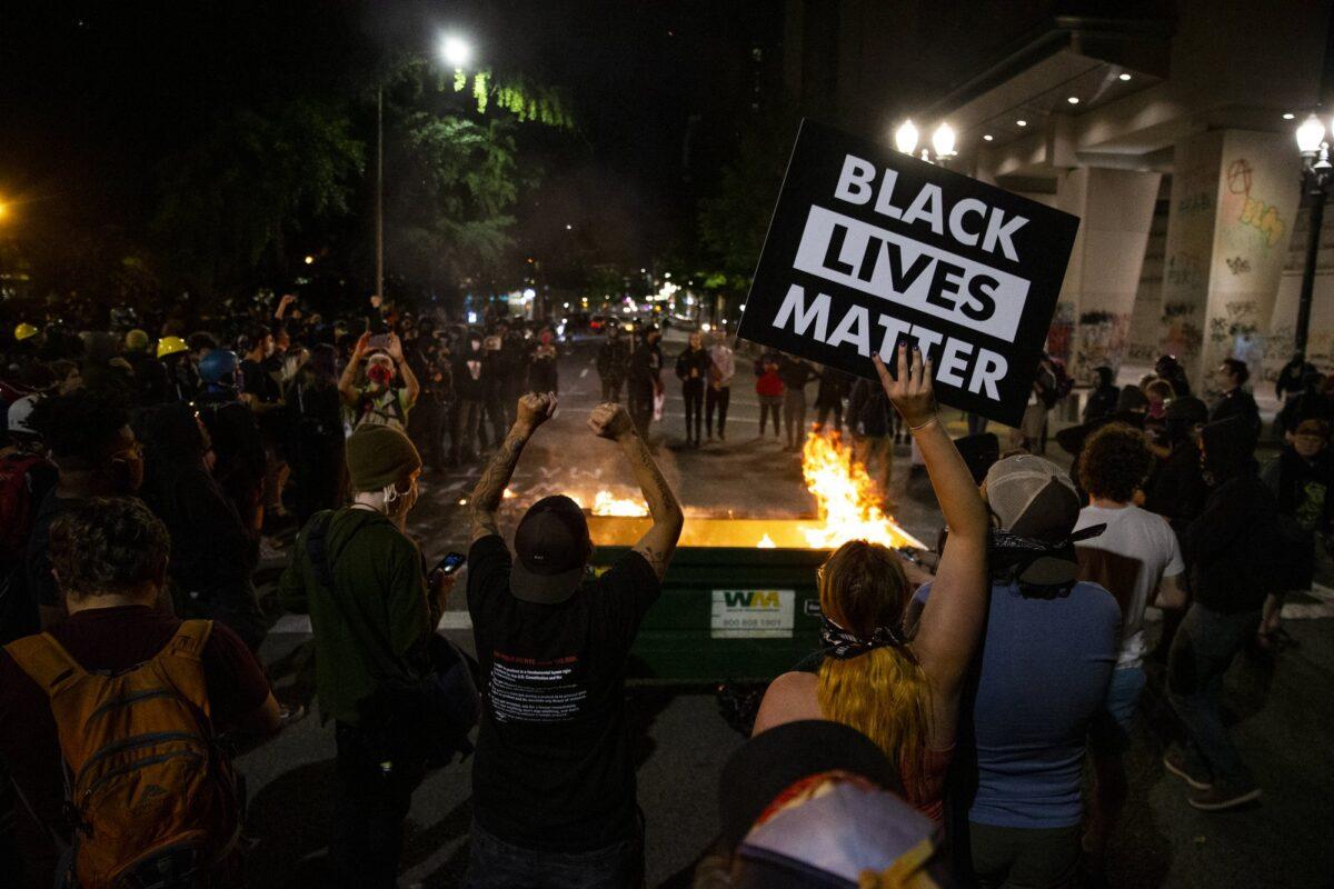 A waste receptacle was moved into the intersection of SW 3rd and Main and its contents set on fire as protesters gathered in downtown Portland on July 10, 2020. (Dave Killen/The Oregonian via AP)