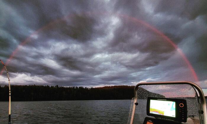 A Rare Spectacle: Fisherman Captures a Stunning Image of a Red Rainbow Over Finnish Lake