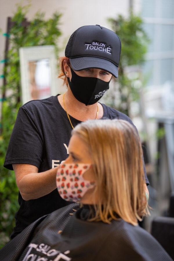 Christina Maniaci cuts a customer's hair at Salon Touché in Redondo Beach, Los Angeles County, on July 22, 2020. (John Fredricks/The Epoch Times)