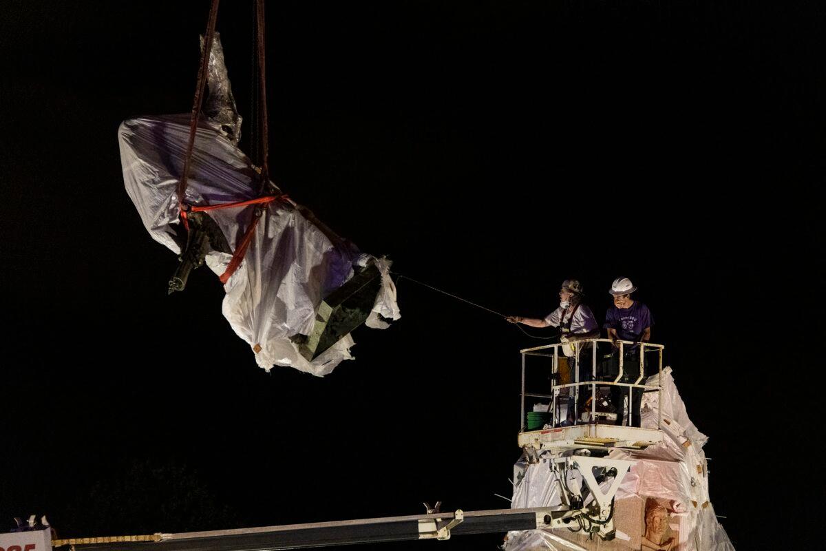 City municipal crews help guide the Christopher Columbus statue in Grant Park as it is removed by a crane in Chicago in the pre-dawn hours of July 24, 2020. (Tyler LaRiviere/Sun-Times/Chicago Sun-Times via AP)