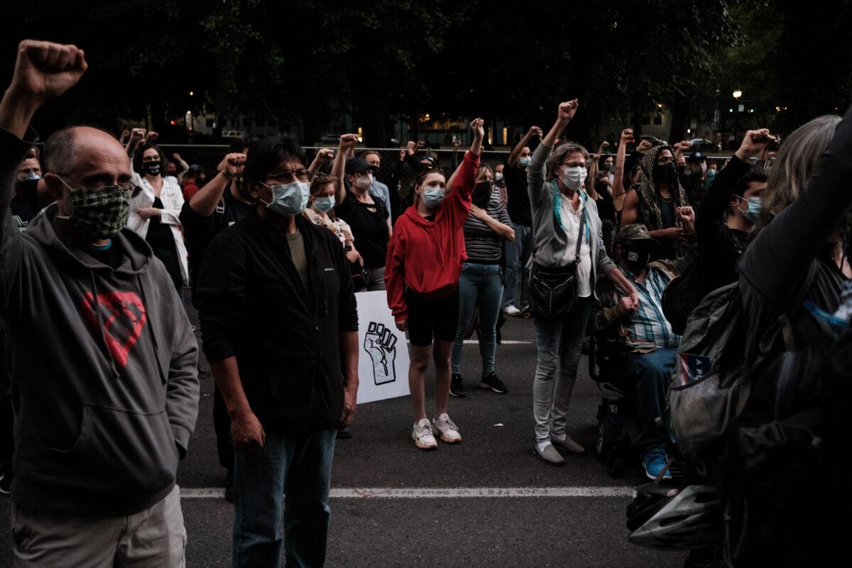 Protestors raise their hands up in solidarity after Portland Commissioner Jo Ann Hardesty spoke, at the Multnomah County Justice Center in Portland, Ore., on July 17, 2020. (Mason Trinca/Getty Images)