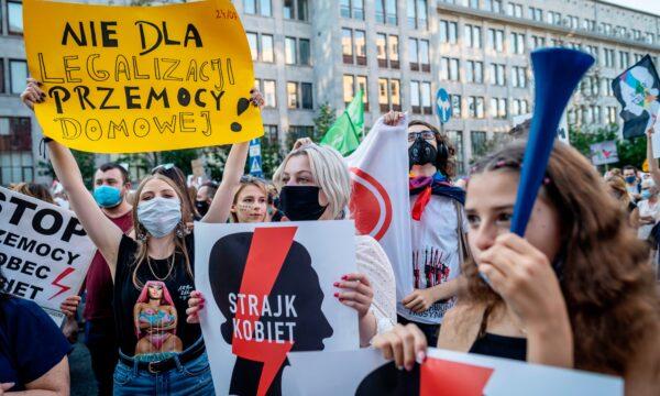 Protesters hold banners reading "No to legalization of domestic violence" and "Women's Strike" as they take part in protest against the Polish government plans to withdraw from the Istanbul Convention, in Warsaw, Poland, on July 24, 2020. (Wojtek Radwanski/AFP via Getty Images)