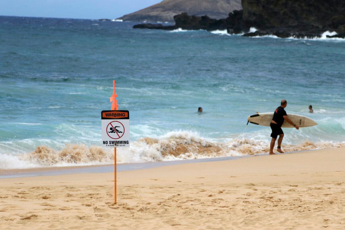 A surfer leaves the water in Honolulu, Hawaii, on July 25, 2020, as Hurricane Douglas approaches.(Caleb Jones/AP Photo)
