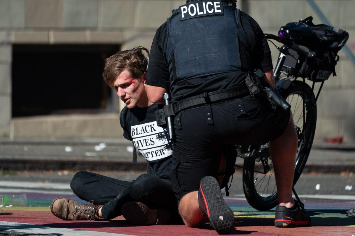 Police detain a demonstrator during rioting in Seattle, on July 25, 2020. (David Ryder/Getty Images)