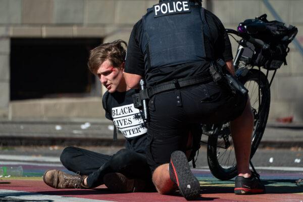 Police detain a demonstrator during rioting in Seattle, on July 25, 2020. (David Ryder/Getty Images)