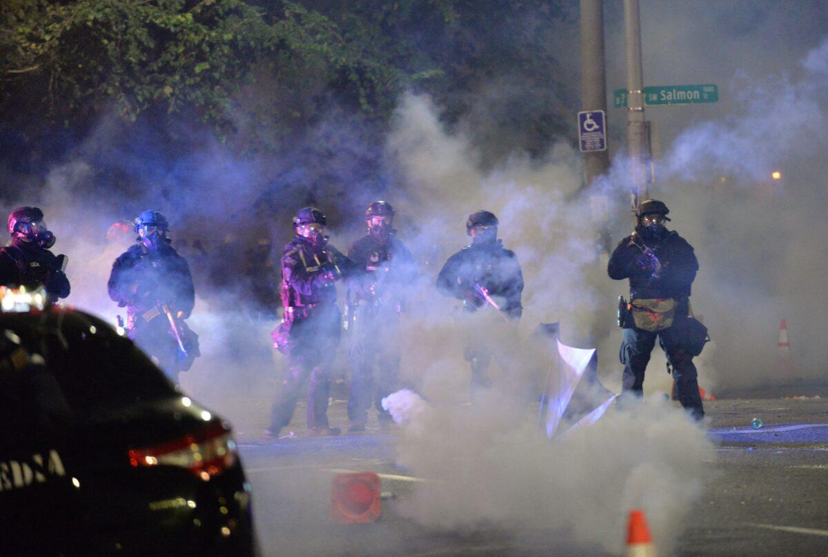  Law enforcement officials stand in a cloud of tear gas in Portland, Ore., early July 26, 2020. (Ankur Dholakia/AFP via Getty Images)