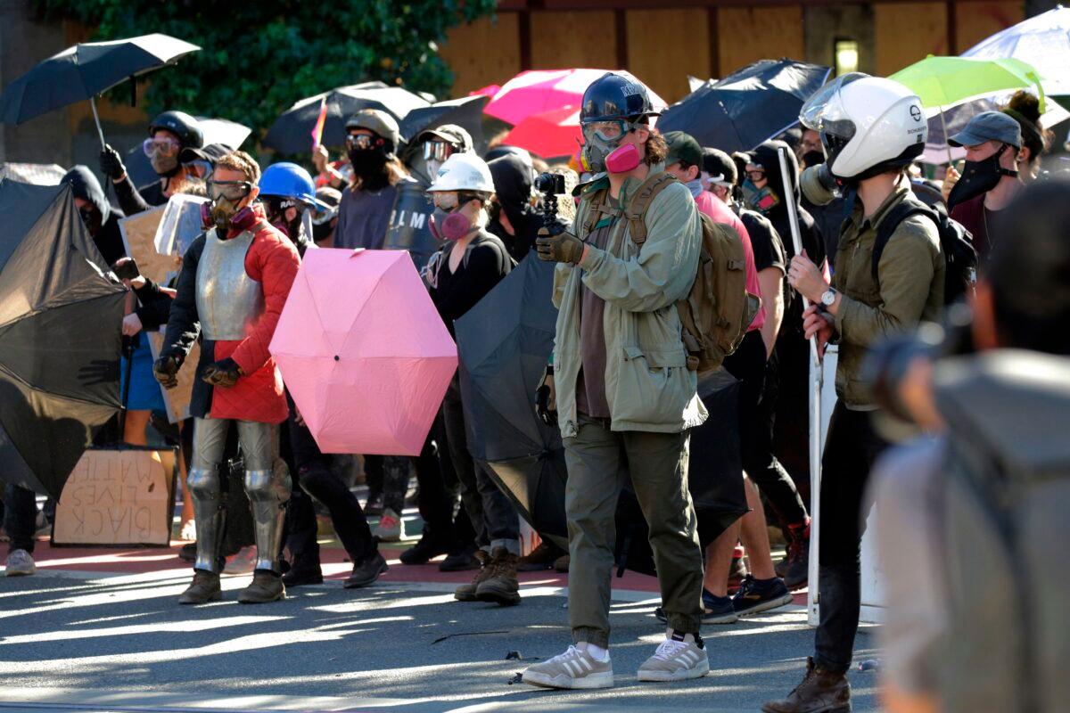 Protesters hold umbrellas as they confront police following the "Youth Day of Action and Solidarity with Portland" demonstration, which devolved into a riot, in Seattle on July 25, 2020. (Jason Redmond/AFP via Getty Images)