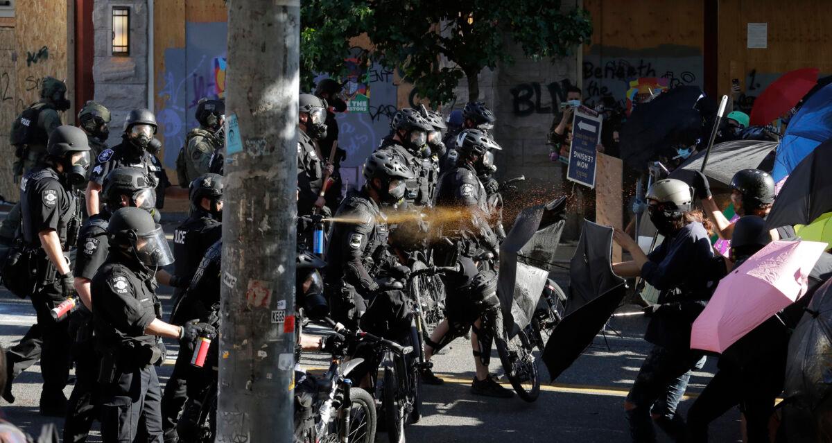 Police pepper spray violent demonstrators during rioting in Seattle, on July 25, 2020. (Ted S. Warren/AP Photo)