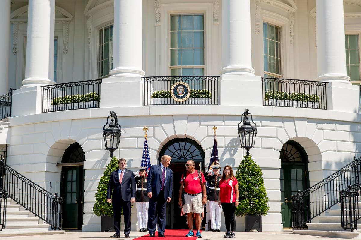 President Donald Trump, Veterans Affairs Secretary Robert Wilkie, left, and Karen Pence, the wife of Vice President Mike Pence, right, pose for photographs with Terry Sharpe, third from right, known as the "Walking Marine" as he arrives at the White House in Washington on July 27, 2020. (Andrew Harnik/AP Photo)