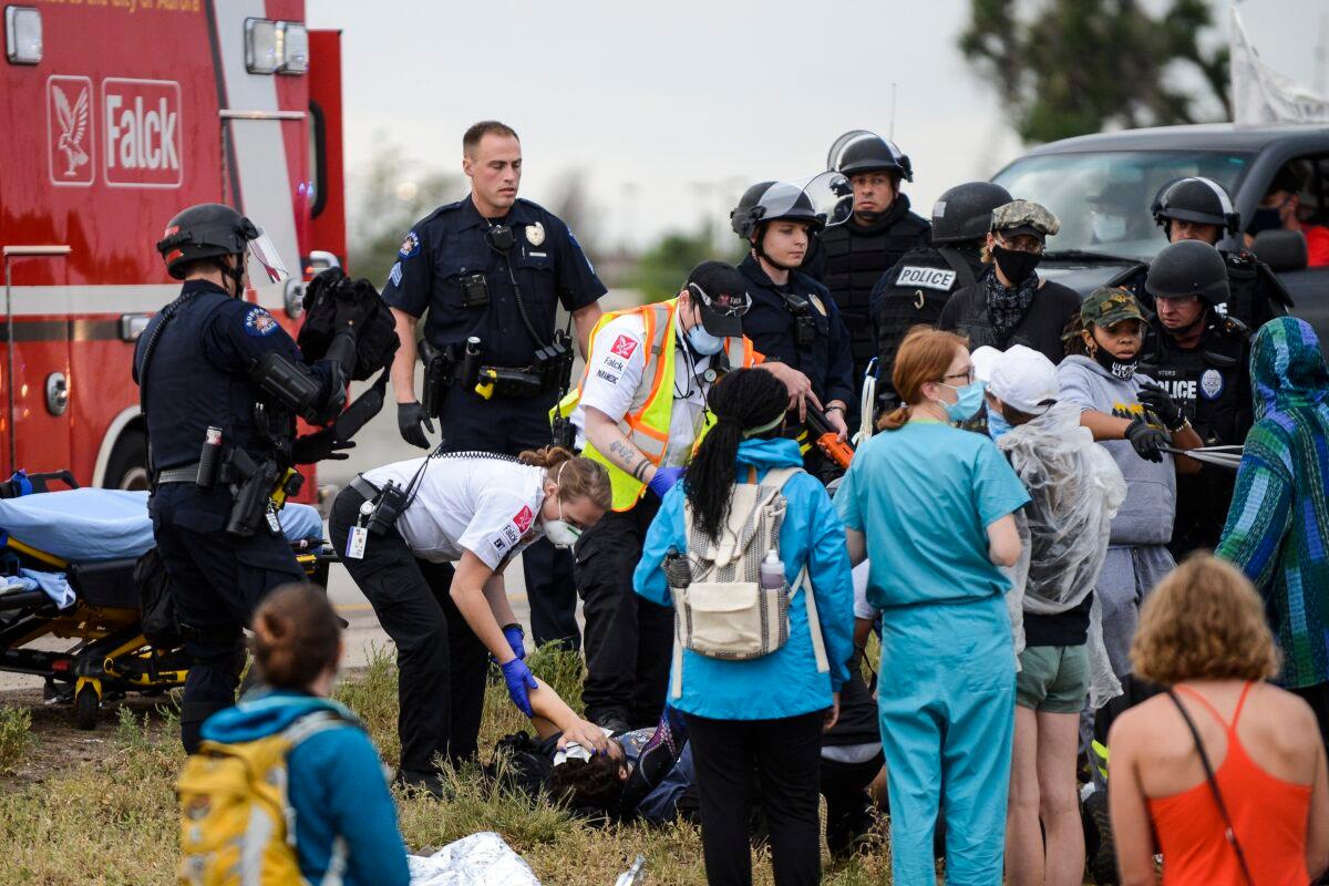 Paramedics tend to a man who was shot during a protest that was blocking I-225 in Aurora, Colo., on July 25, 2020. (Michael Ciaglo/Getty Images)