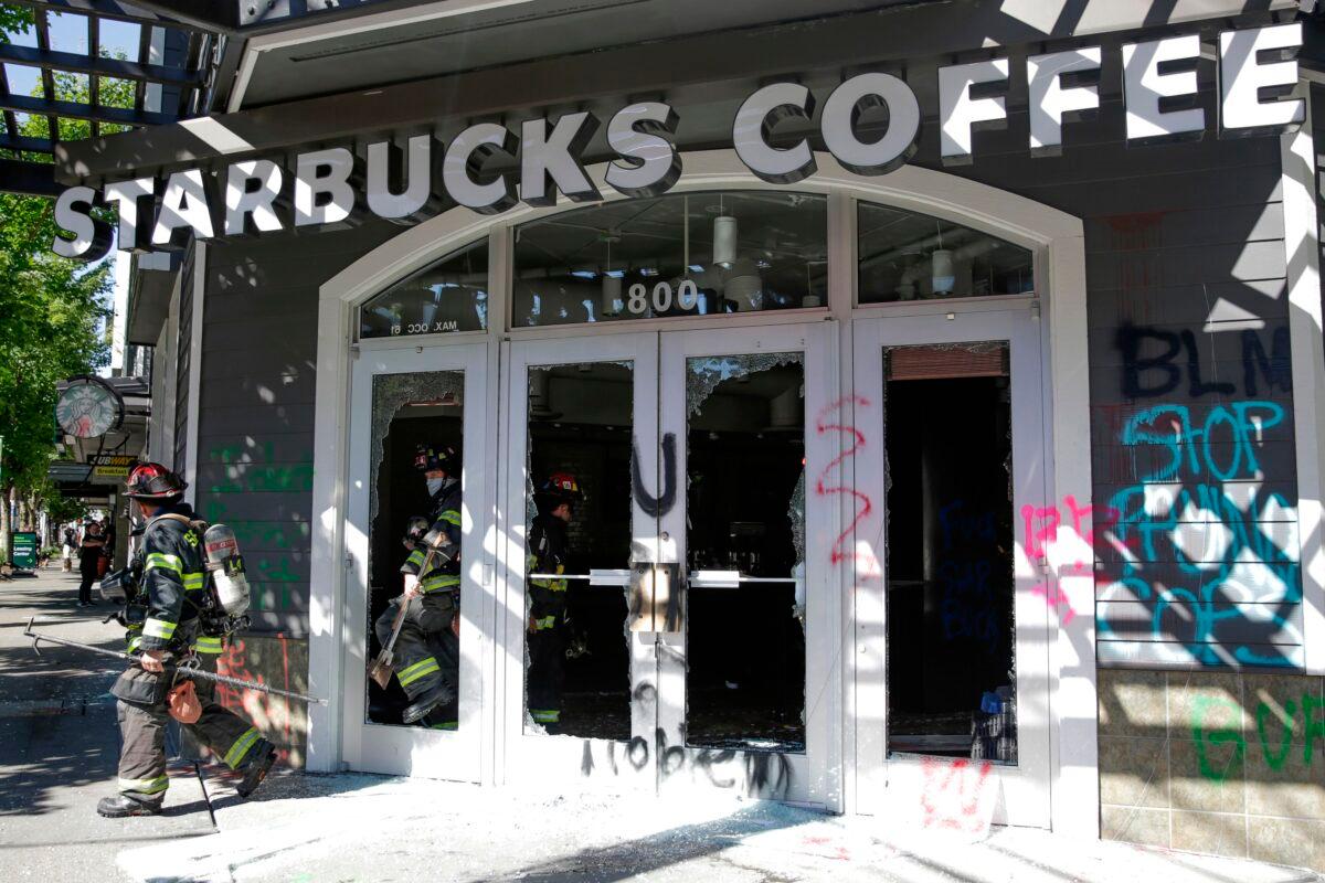 Firefighters exit a Starbucks Coffee that was vandalized by rioters during a "Youth Day of Action and Solidarity with Portland" demonstration in Seattle, Wash., on July 25, 2020. (Jason Redmond/AFP via Getty Images)