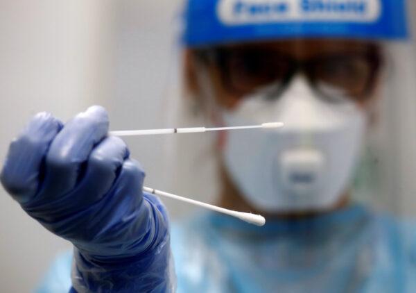 A doctor holds a test stick before a voluntary coronavirus disease (COVID-19) test at the new Duesseldorf Airport Corona Test Center in Duesseldorf, Germany, on July 27, 2020. (Wolfgang Rattay/Reuters)