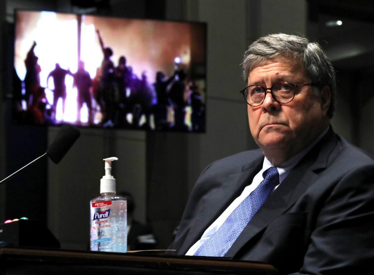 Attorney General William Barr watches a Republican Exhibit video of people rioting, during the House Judiciary Committee hearing in the Congressional Auditorium at the U.S. Capitol Visitors Center in Washington, on July 28, 2020. (Chip Somodevilla/AFP via Getty Images)