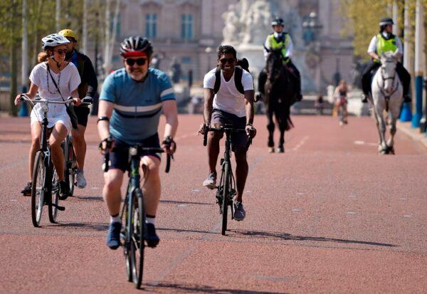 Cyclists ride their bicycles on The Mall road, outside Buckingham Palace in central London on April 11, 2020. (Niklas Halle'n/AFP via Getty Images)