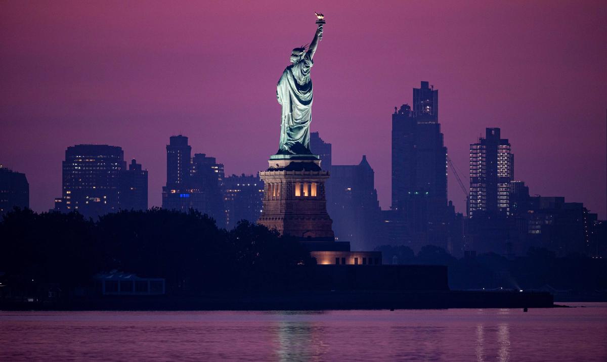 The Statue of Liberty in front of the skyline of Brooklyn before sunrise in New York City on July 9, 2020. (Johannes Eisele/AFP via Getty Images)