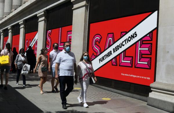 <br/>Pedestrians wearing protective face masks walk past signs advertising sales outside a Selfridges store, amid the coronavirus disease (COVID-19) outbreak, at Oxford Street in London, Britain, on July 18, 2020. (Simon Dawson/Reuters)