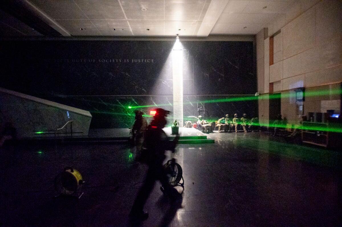 Green lines cast by rioters' laser pointers cross the darkened lobby of the Mark O. Hatfield U.S. Courthouse as federal officers wait, in Portland, Ore., on July 24, 2020. (Noah Berger/AP Photo)