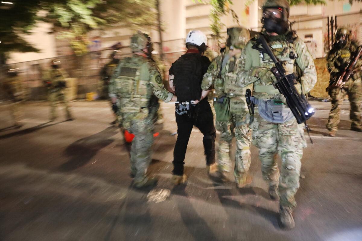 Federal police make an arrest as they confront rioters in front of the Mark O. Hatfield federal courthouse in downtown Portland on July 26, 2020. (Spencer Platt/Getty Images)