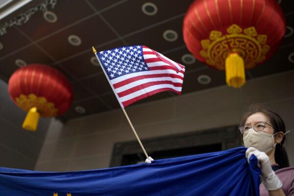 A protester holds a US flag outside of the Chinese consulate in Houston on July 24, 2020, after the US State Department ordered China to close the consulate. (MARK FELIX/AFP /AFP via Getty Images)