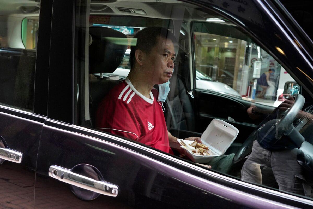 A man eats lunch inside a vehicle in Hong Kong, on July 29, 2020. (Vincent Yu/AP Photo)