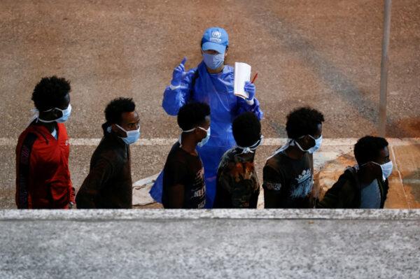 Rescued migrants are being checked by a United Nations High Commissioner for Refugees (UNHCR) worker upon their arrival in Senglea, in Valletta's Grand Harbor, Malta, on July 27, 2020. (Reuters/Darrin Zammit Lupi/File Photo)