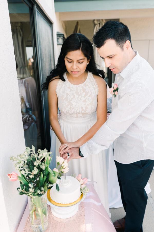 Brad and Yvette cut the cake at their wedding on May 23, 2020. (Jim Kennedy Photography)
