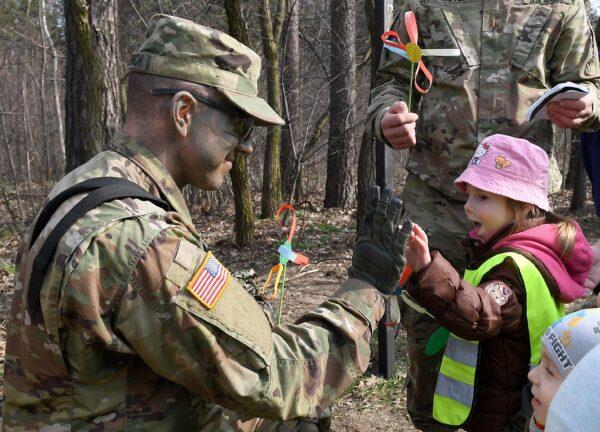 U.S. soldier gives high five to a child in the Wesola district of Polands capital Warsaw on March 29, 2017. (Janek Skarzynski/AFP via Getty Images)