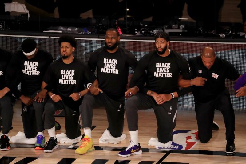 LeBron James, center, and Anthony Davis, second from right, of the Los Angeles Lakers, kneel with other players and personnel during the national anthem prior to the game against the LA Clippers at The Arena at ESPN Wide World Of Sports Complex in Lake Buena Vista, Fla. on July 30, 2020. (Mike Ehrmann/Pool Photo via USA TODAY Sports)