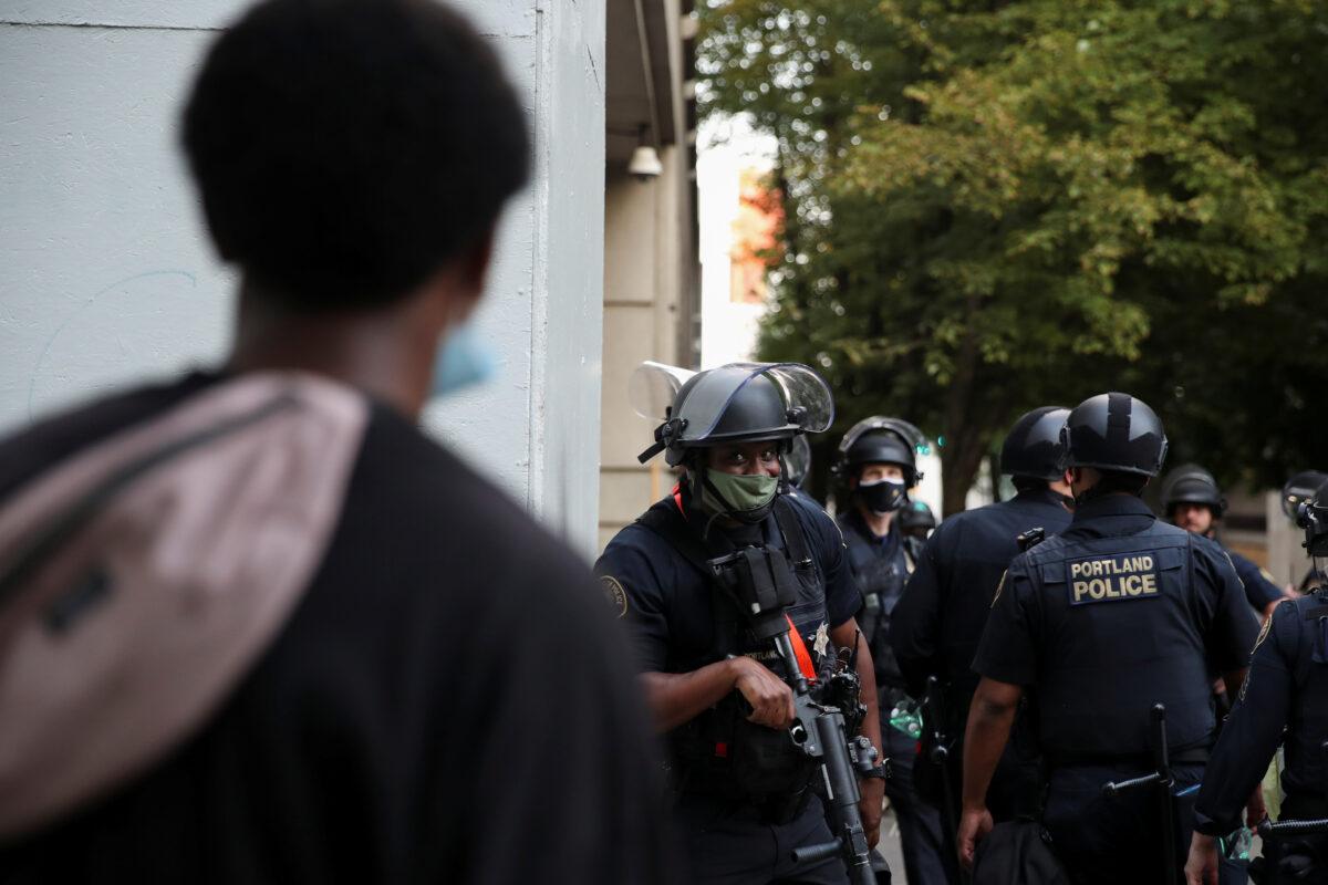 A police officer looks on during a protest in Portland, Ore., on July 30, 2020. (Caitlin Ochs/Reuters)