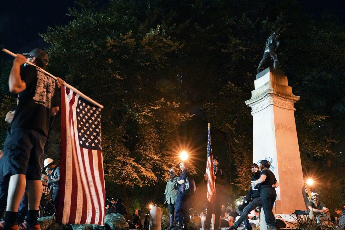 Protesters walk through Lownsdale Square after some tore down police tape and signs aimed at keeping people out, near the Mark O. Hatfield Courthouse in Portland, Ore., on July 30, 2020. (Nathan Howard/Getty Images)