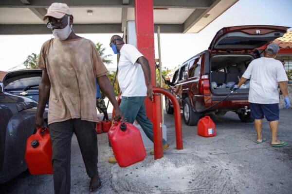 A resident walks with containers filled with gasoline at Cooper's gas station before the arrival of Hurricane Isaias in Freeport, Grand Bahama, Bahamas on July 31, 2020. (Tim Aylen/AP Photo)
