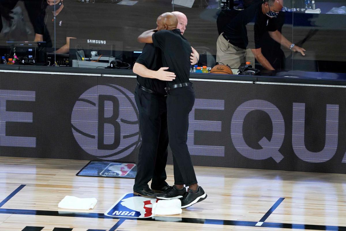 Orlando Magic head coach Steve Clifford, left, and Brooklyn Nets head coach Jacque Vaughn hug before the start of an NBA basketball game Friday, July 31, 2020, in Lake Buena Vista, Fla. (Ashley Landis, Pool/AP Photo)