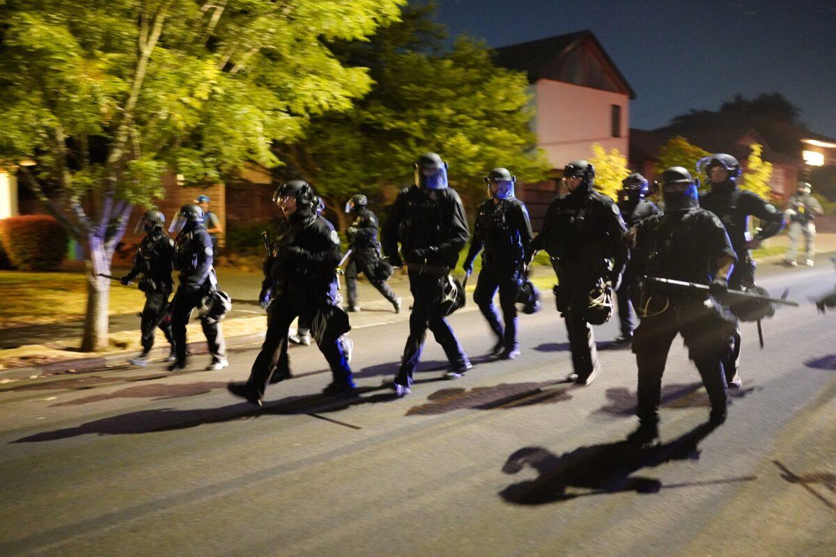 Police officers pursue a crowd of about 200 after forcing the group to disperse from a law enforcement precinct in Portland, Ore., on Aug. 1, 2020. (Nathan Howard/Getty Images)