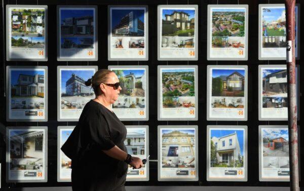 A woman walks past a real estate agent's window advertising houses for sale and auction in Melbourne on May 1, 2019. (WILLIAM WEST/Getty Images)