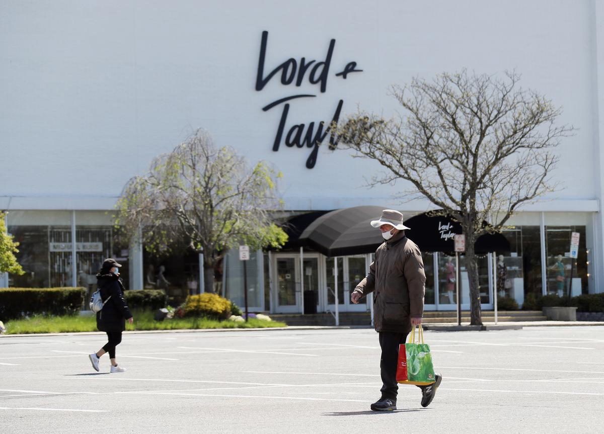 Pedestrians walk past a shuttered Lord and Taylor department store following their filing for bankruptcy amid the COVID-19 pandemic in Garden City, N.Y., on May 12, 2020. (Bruce Bennett/Getty Images)